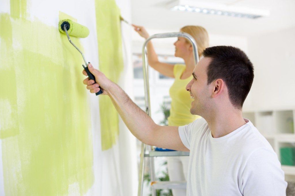 Smiling young couple painting home