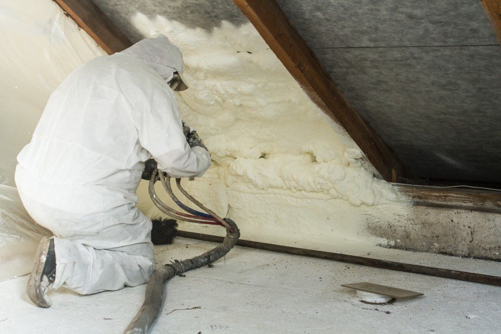 Man placing wool in attic