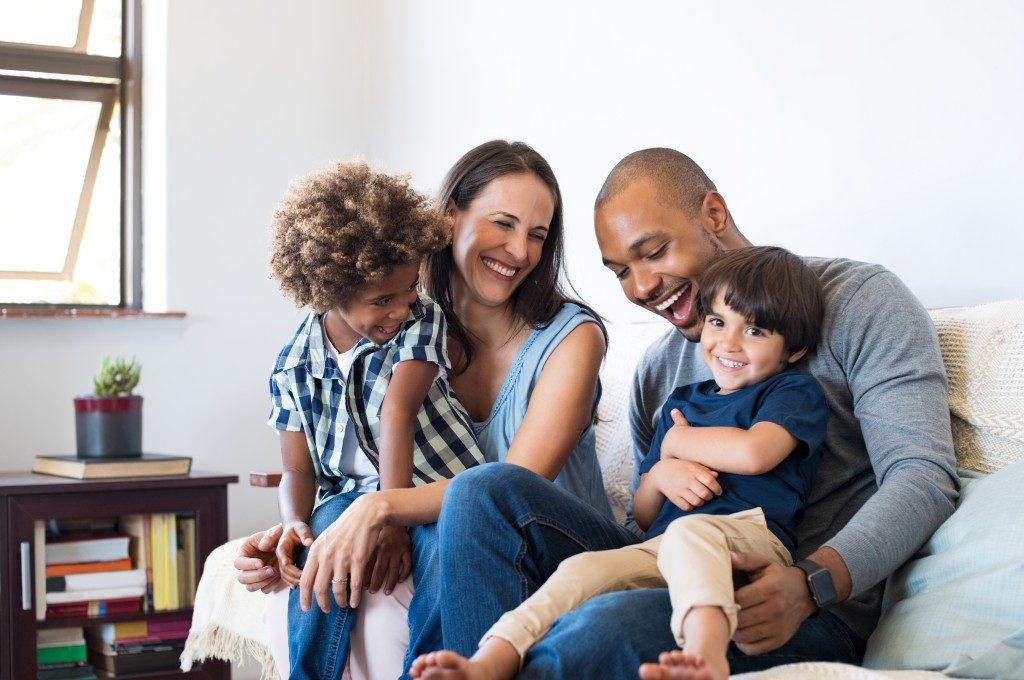 Family sitting on the sofa while laughing