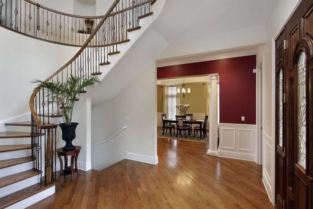 Foyer in luxury home with curved staircase and view into dining room