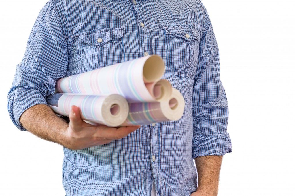 Man carrying rolls of wallpaper