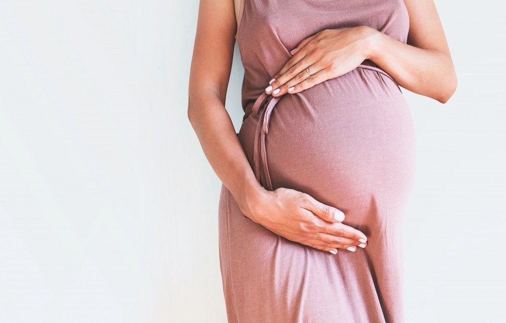 pregnant woman holding her stomach