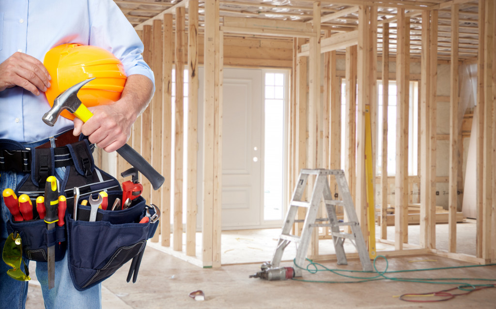 A man with a tool belt in an unfinished house