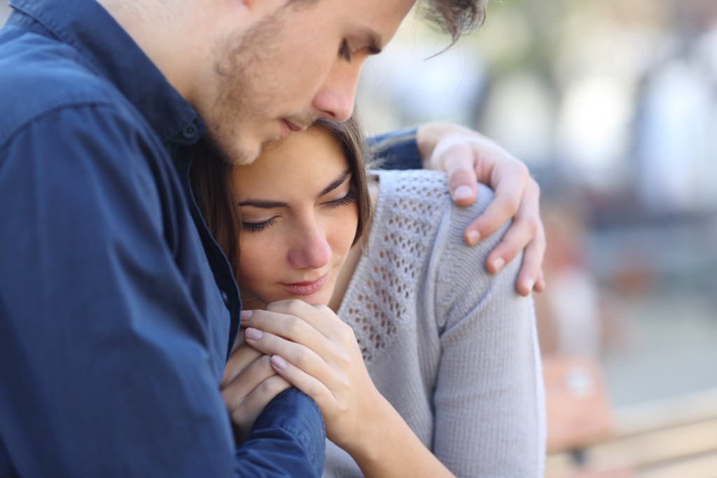 Man comforts woman after tragedy