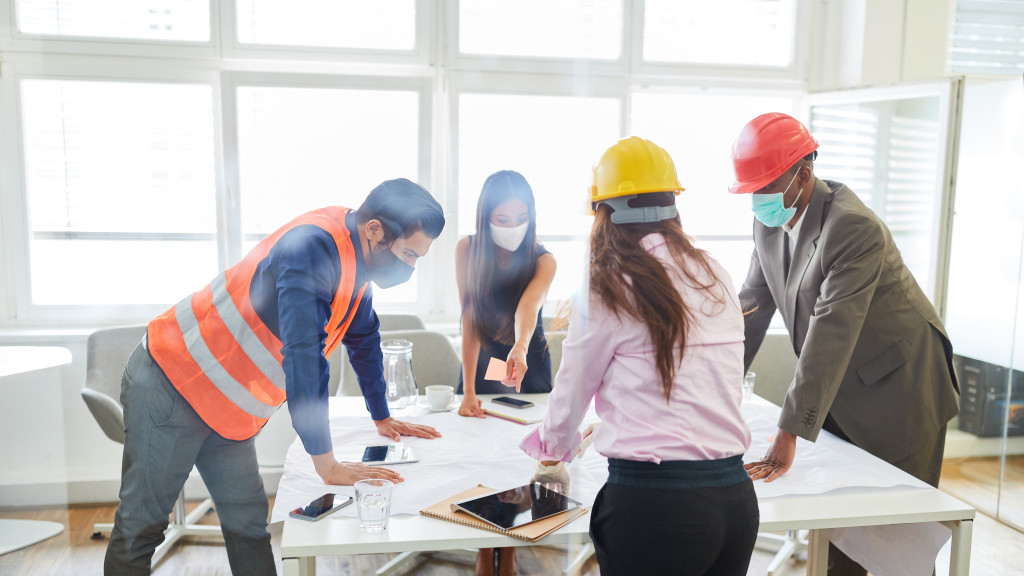 group of architects discussing a blueprint of a construction project