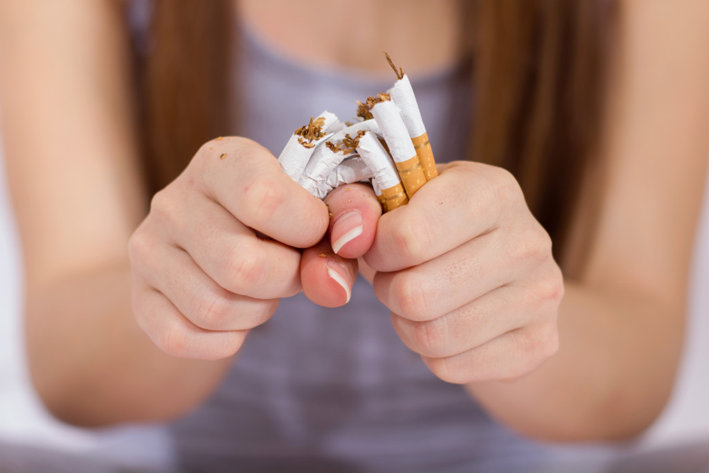 Woman breaks a bunch of cigarettes using her hands