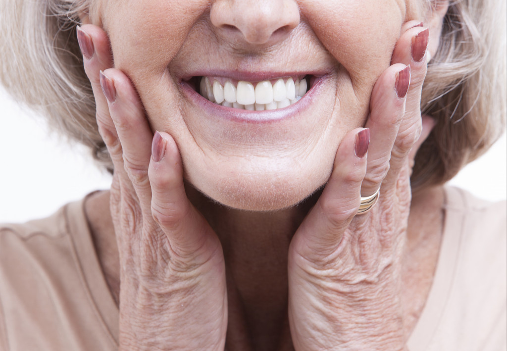 A smiling older woman showing white teeth